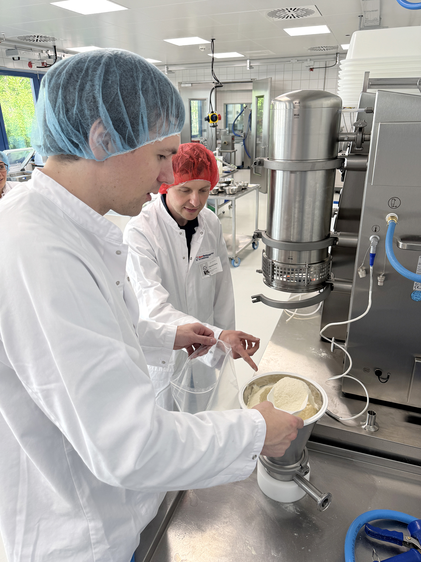 Two technologists using a fluid bed agglomerator